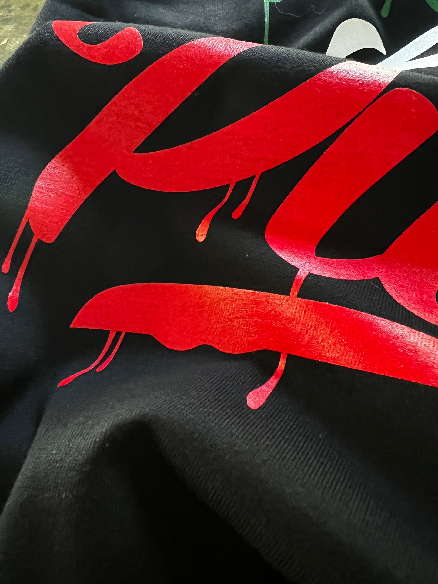Close-up detail of Pilas Clothing Co. PLP Drip Mexican Flag shirt in black with bold red graffiti-style drip lettering, showcasing premium cotton fabric and vibrant screen print quality inspired by Mexico colors