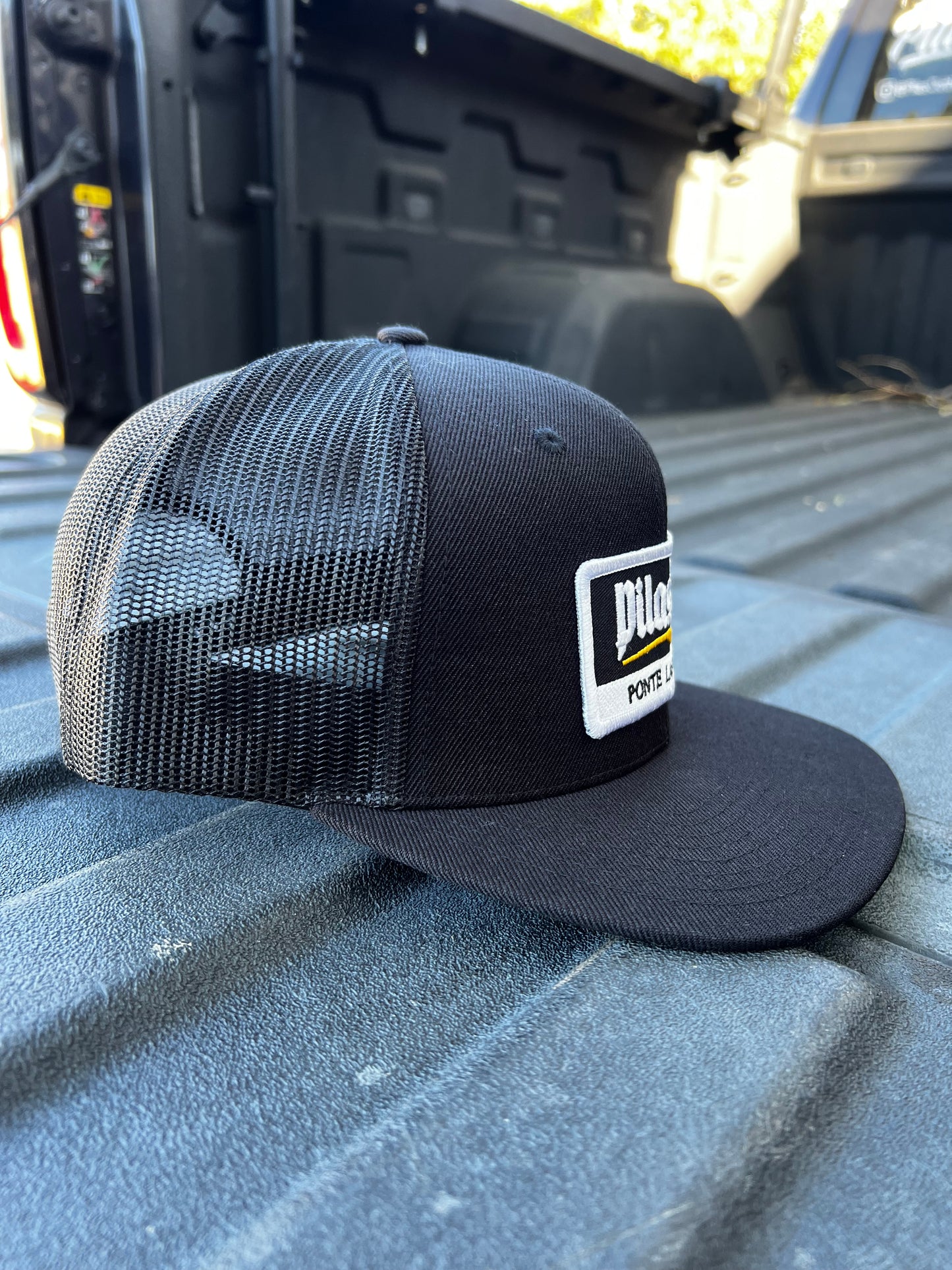 Pilas Co Ponte Las Pilas trucker hat in pickup truck bed - Latino construction worker snapback cap